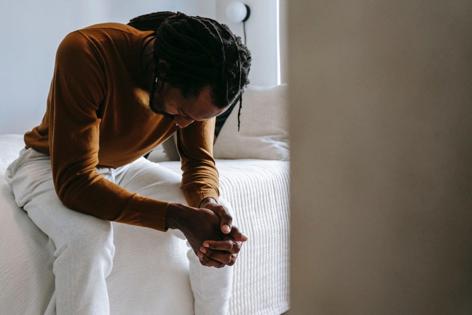 Photo by Alex Green: https://www.pexels.com/photo/desperate-black-man-sitting-on-bed-in-deep-thoughts-5700171/